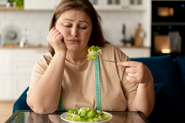 mulher-com-semblante-triste-comendo-salada-com-dificuldade-de emagrecer