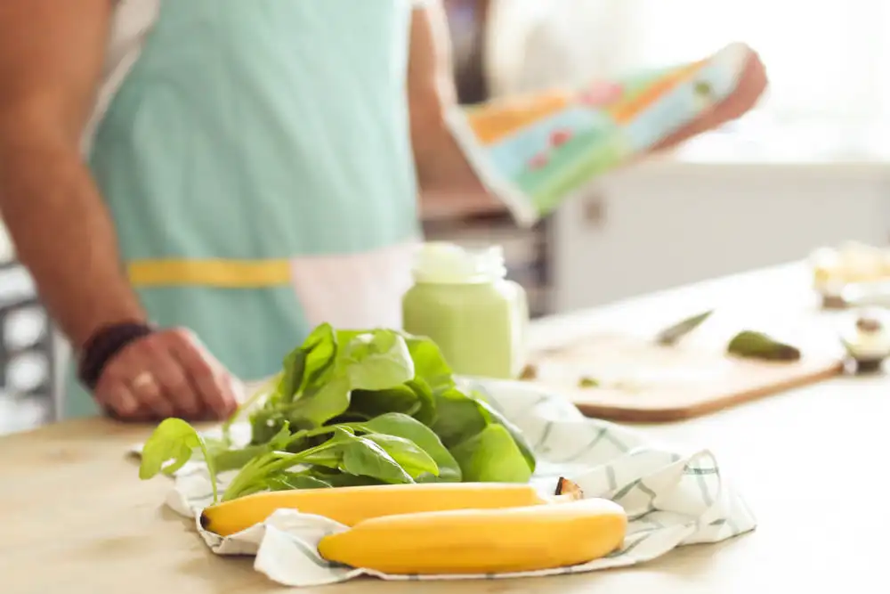 homem-branco-usando-avental-de-cozinha-verde-cozinhando